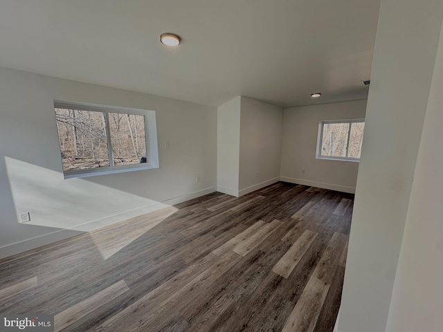 empty room with visible vents, wood finished floors, and baseboards