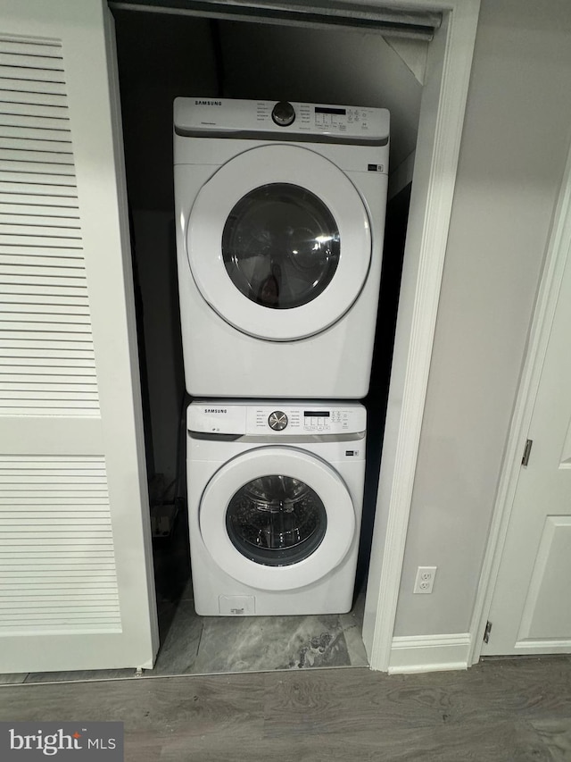 washroom featuring stacked washer and clothes dryer and laundry area