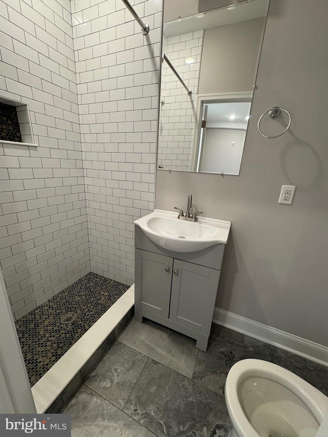 full bath featuring baseboards, a stall shower, and vanity