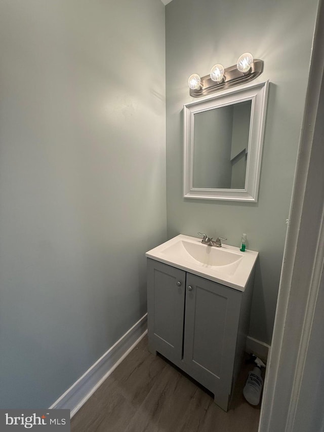 bathroom featuring vanity, wood finished floors, and baseboards