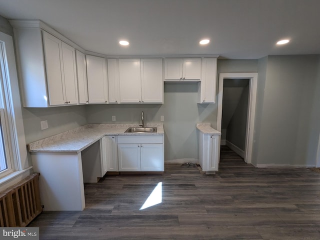 kitchen featuring a sink, recessed lighting, white cabinets, and radiator heating unit