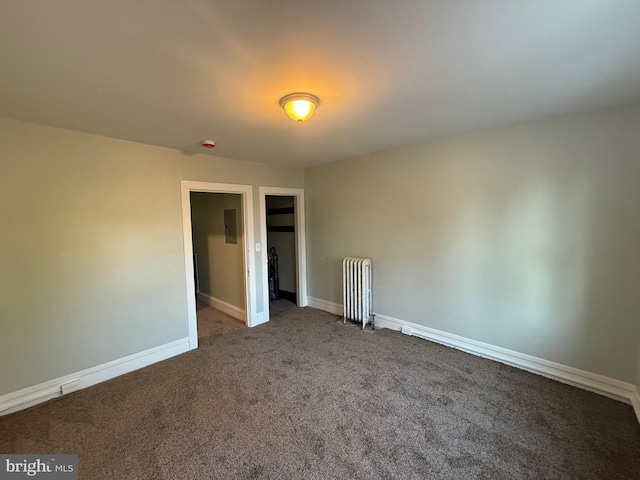 unfurnished bedroom with a closet, baseboards, radiator, and carpet