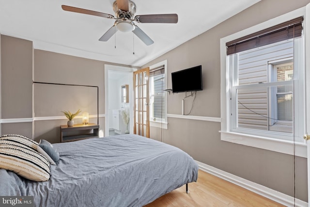 bedroom featuring wood finished floors, baseboards, and ceiling fan