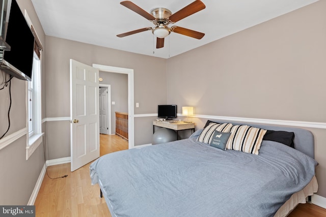 bedroom featuring baseboards, light wood-style floors, and ceiling fan