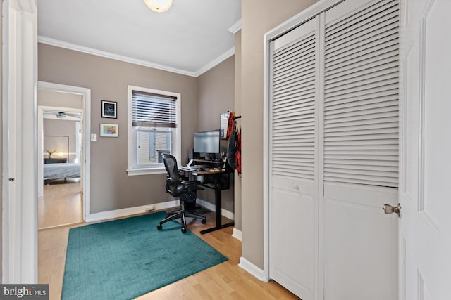 office with baseboards, light wood-style floors, and ornamental molding