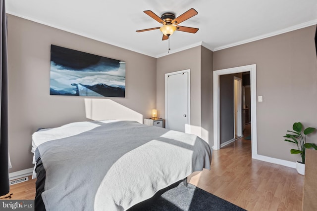 bedroom with ceiling fan, baseboards, ornamental molding, and light wood finished floors