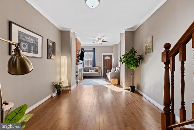 entryway featuring hardwood / wood-style floors, crown molding, stairs, and baseboards