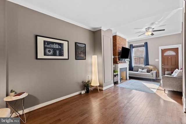 living room featuring hardwood / wood-style flooring, baseboards, and ornamental molding