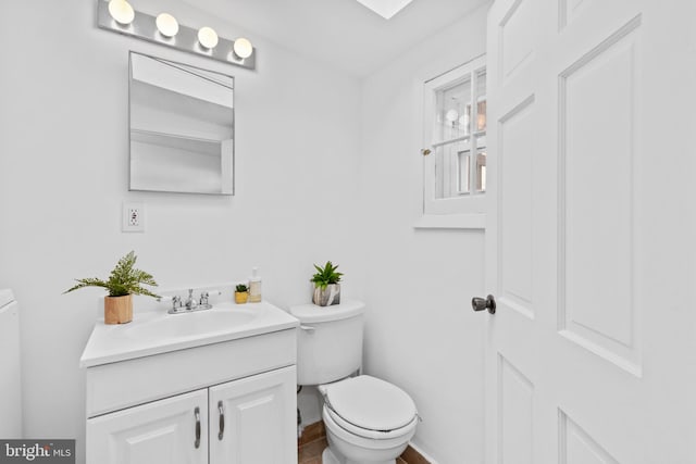 bathroom featuring baseboards, toilet, and vanity