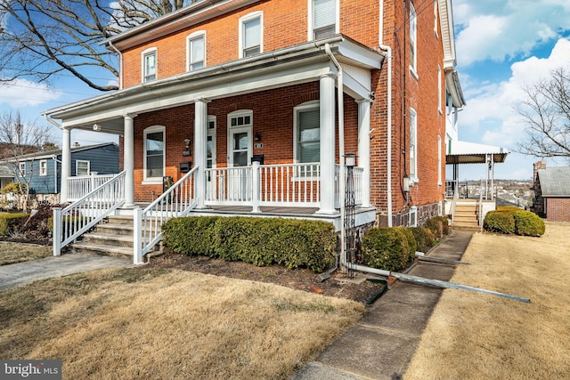 view of front of home with brick siding and covered porch