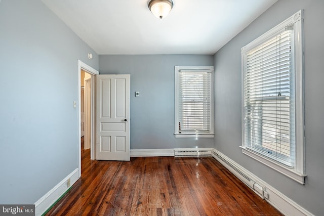 empty room with visible vents, a healthy amount of sunlight, baseboards, and wood finished floors