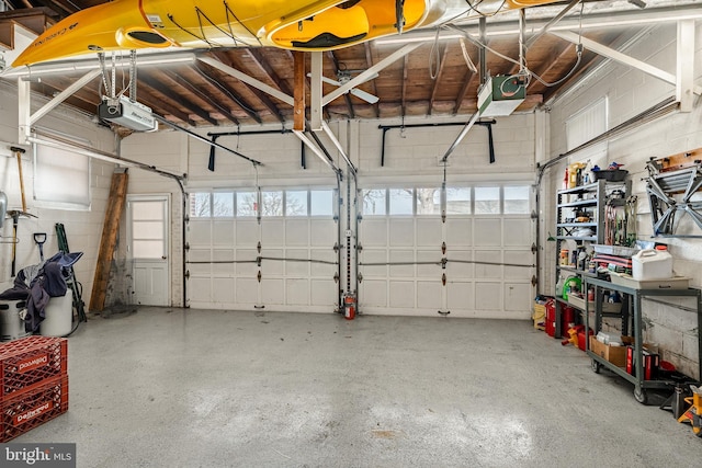 garage featuring a garage door opener and concrete block wall