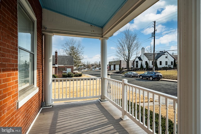 wooden deck with a residential view and a porch