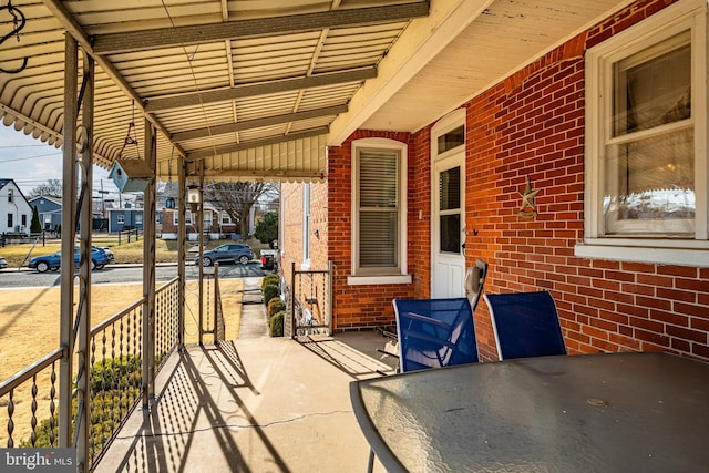 view of patio featuring a residential view, an attached carport, and a porch