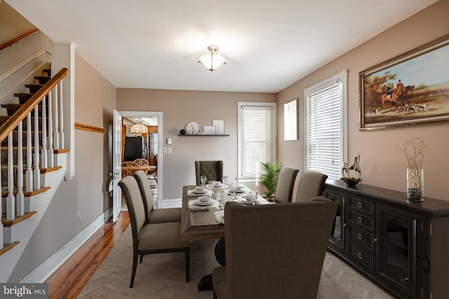 dining area with stairway, light wood-style floors, and baseboards