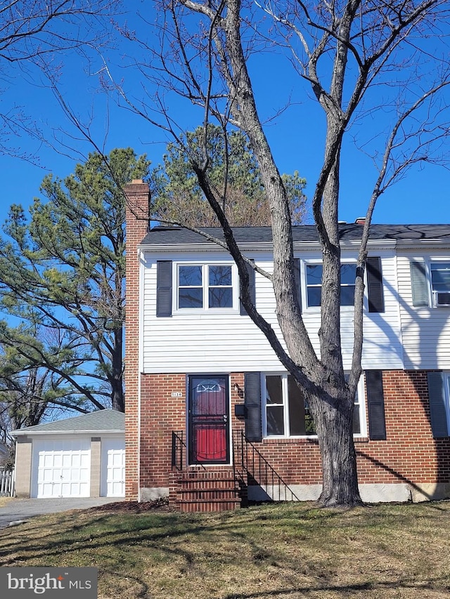 view of front of home featuring a front yard, brick siding, and a chimney