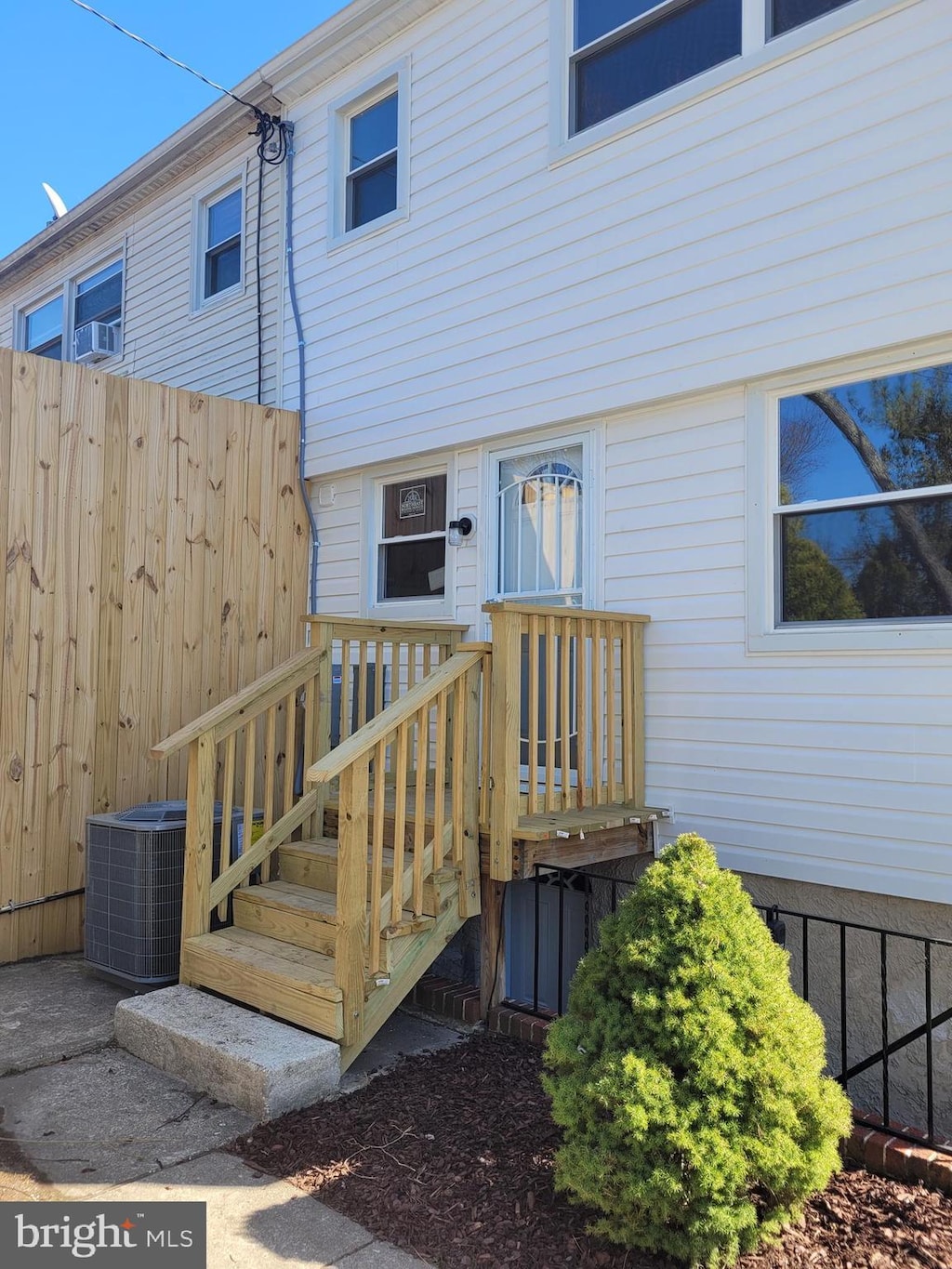 entrance to property with central air condition unit and fence