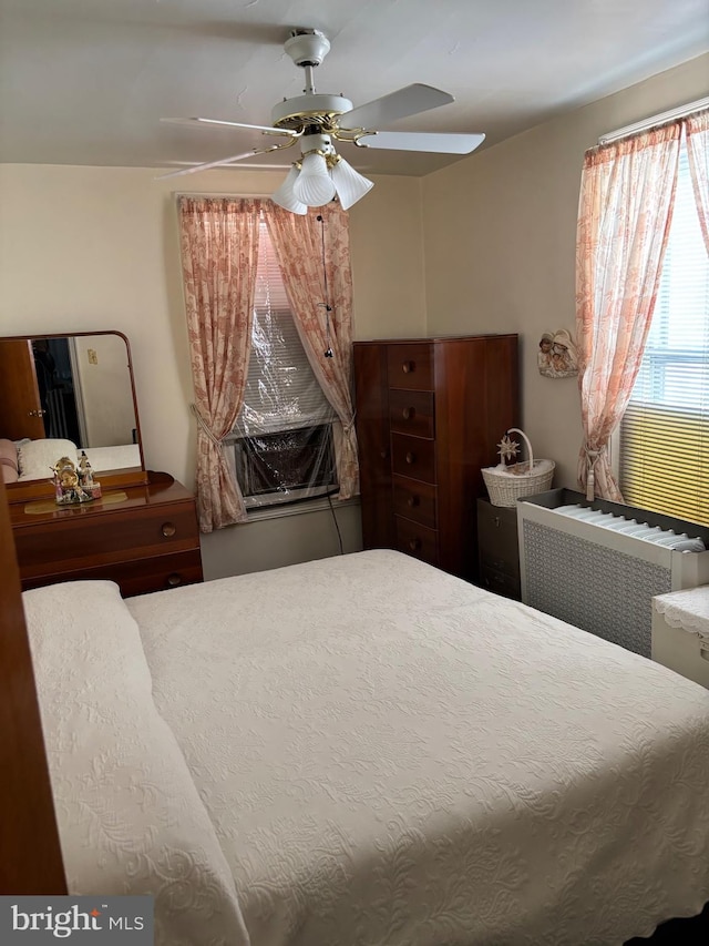 bedroom with a ceiling fan and radiator heating unit