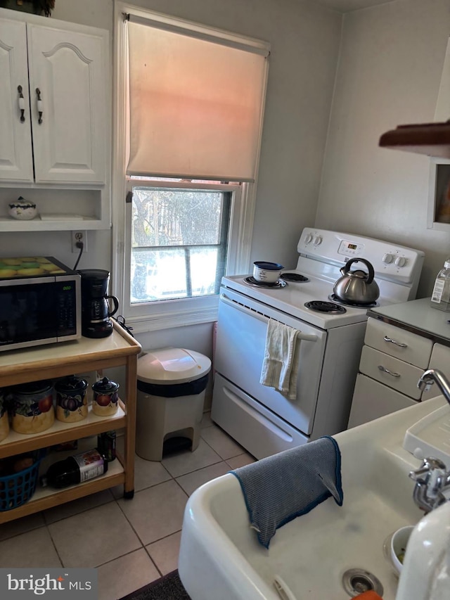 kitchen with white electric range oven, white cabinets, light tile patterned floors, and open shelves