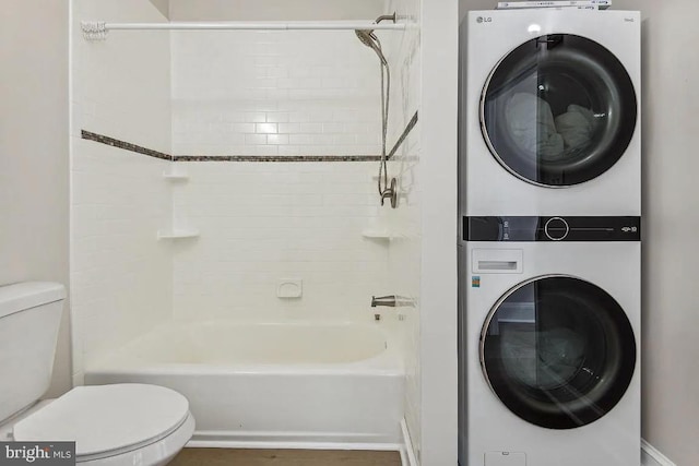 full bath with tub / shower combination, toilet, and stacked washer / dryer