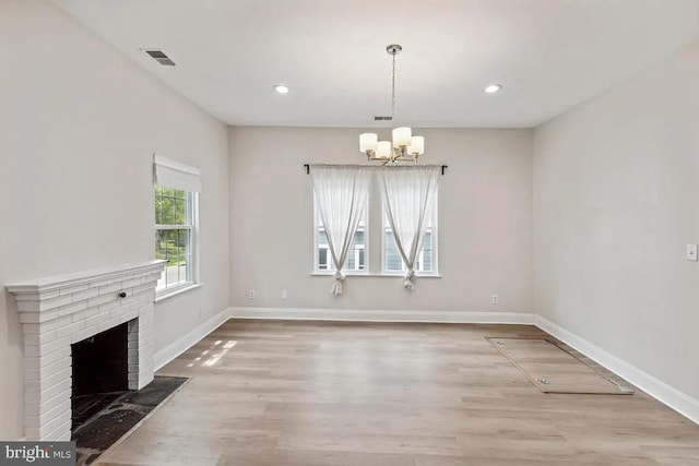 unfurnished dining area featuring visible vents, baseboards, and wood finished floors