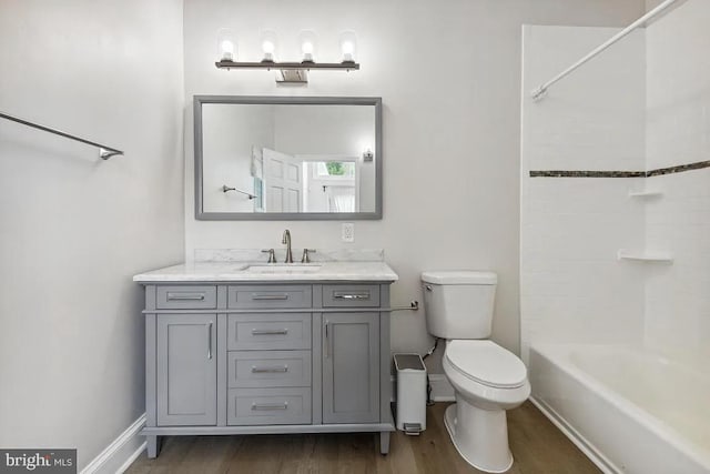 bathroom featuring toilet, vanity, baseboards, and wood finished floors