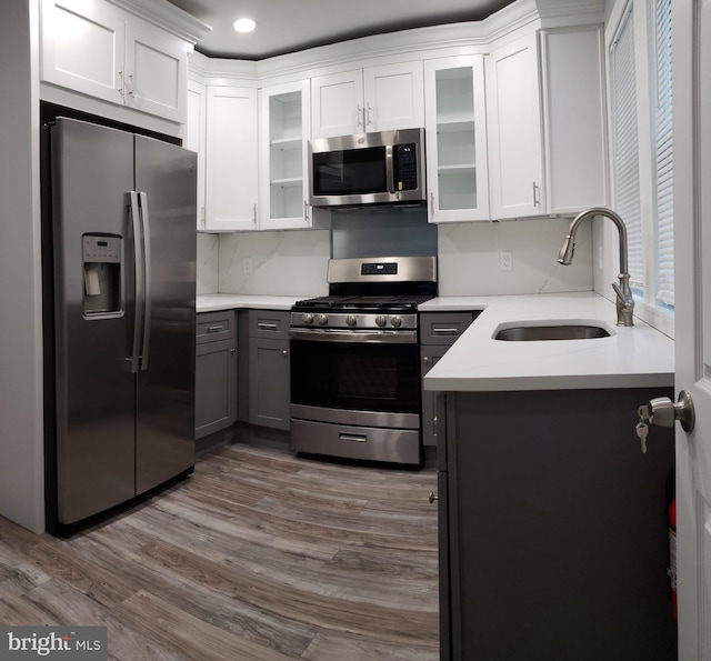 kitchen featuring dark wood-style flooring, white cabinets, appliances with stainless steel finishes, and a sink