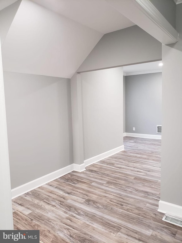 bonus room with lofted ceiling, wood finished floors, visible vents, and baseboards