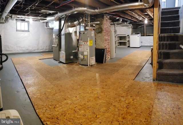 basement featuring stairs, gas water heater, heating unit, and washer / clothes dryer