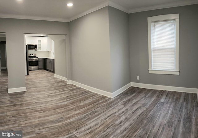 interior space with dark wood finished floors, crown molding, and baseboards