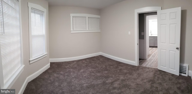 unfurnished bedroom featuring visible vents, baseboards, and carpet flooring