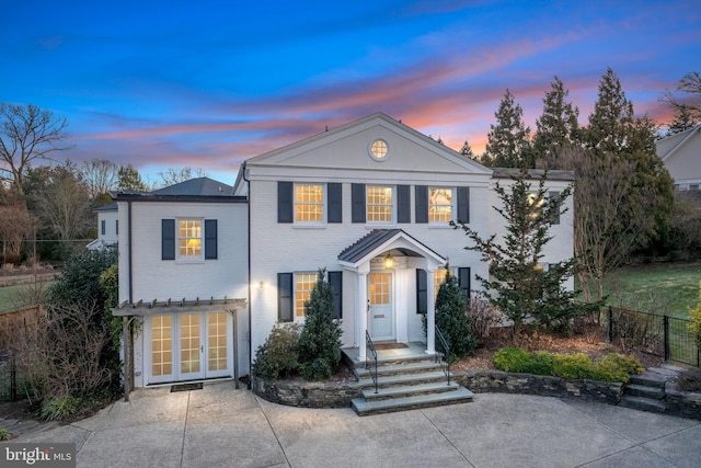 greek revival inspired property with brick siding and fence