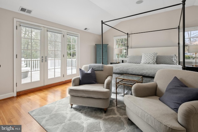 bedroom featuring visible vents, access to outside, wood finished floors, french doors, and vaulted ceiling