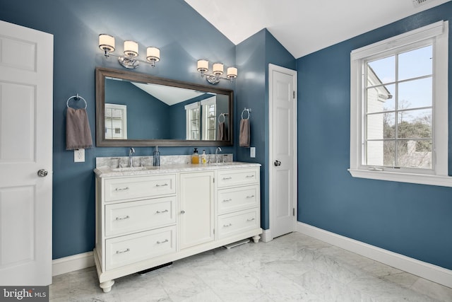 bathroom with vaulted ceiling, baseboards, marble finish floor, and a sink