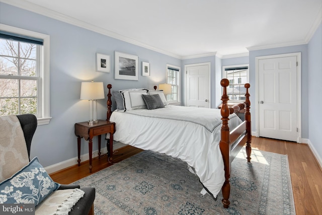 bedroom featuring crown molding, wood finished floors, baseboards, and a closet