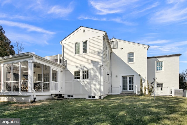 back of house with entry steps, a yard, french doors, and a sunroom