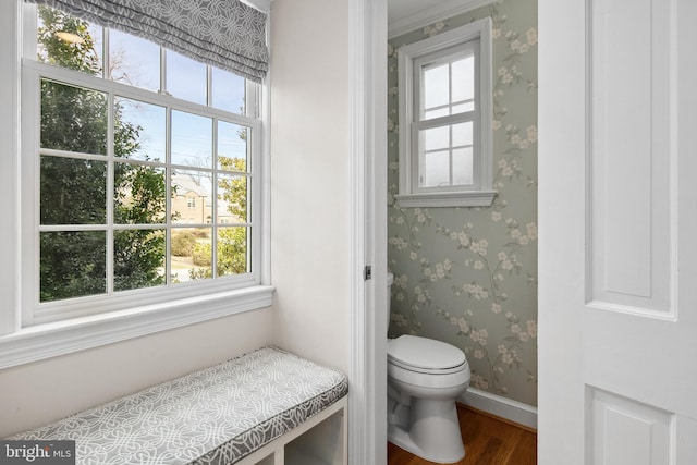 bathroom featuring wallpapered walls, toilet, wood finished floors, and baseboards