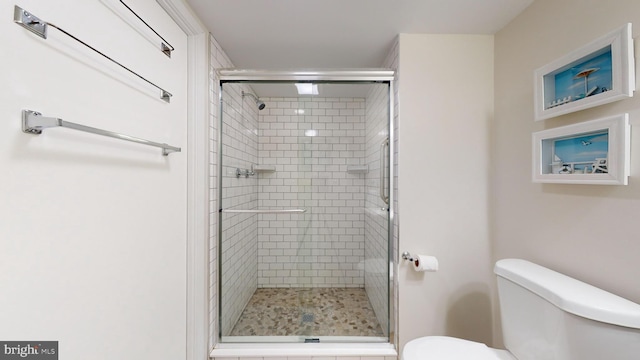 bathroom with toilet and a shower stall