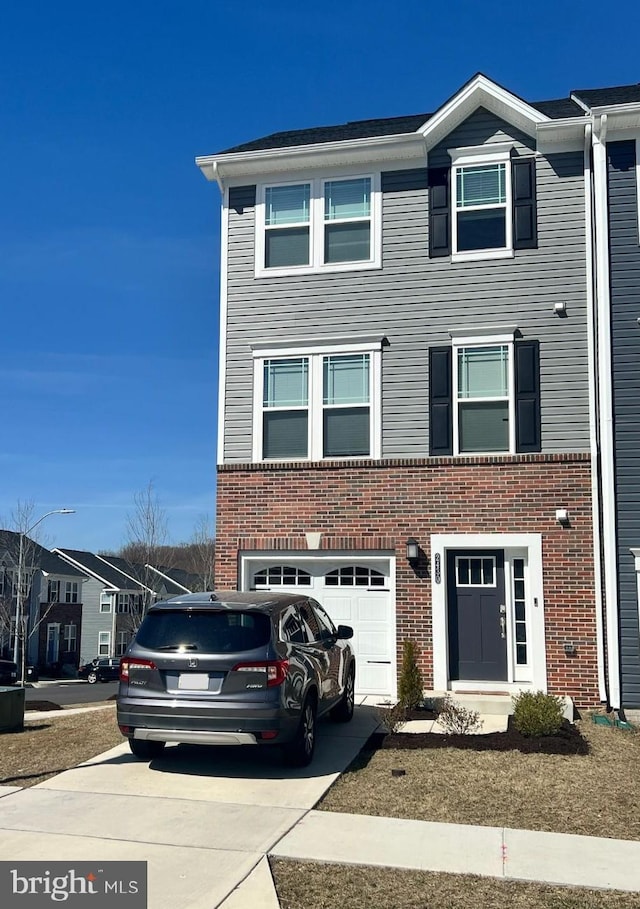 multi unit property with concrete driveway, an attached garage, and brick siding