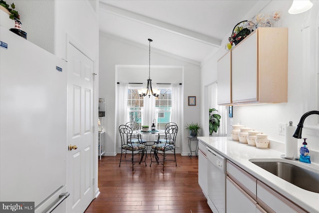 kitchen with white appliances, dark wood finished floors, vaulted ceiling with beams, a sink, and light countertops