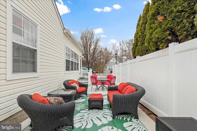 view of patio featuring outdoor lounge area and fence