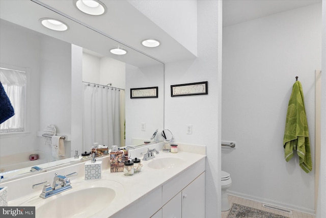 full bathroom featuring a sink, visible vents, toilet, and double vanity