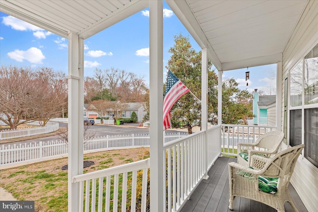 wooden deck featuring covered porch and fence