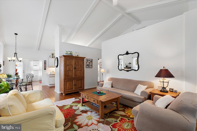 living room with a notable chandelier, beamed ceiling, high vaulted ceiling, and wood finished floors