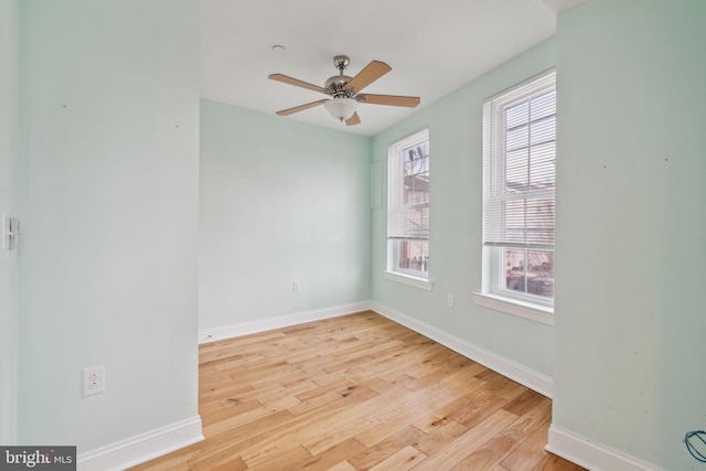 empty room with a ceiling fan, wood finished floors, and baseboards