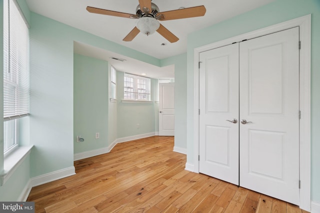 unfurnished bedroom with a closet, visible vents, baseboards, and light wood-style floors