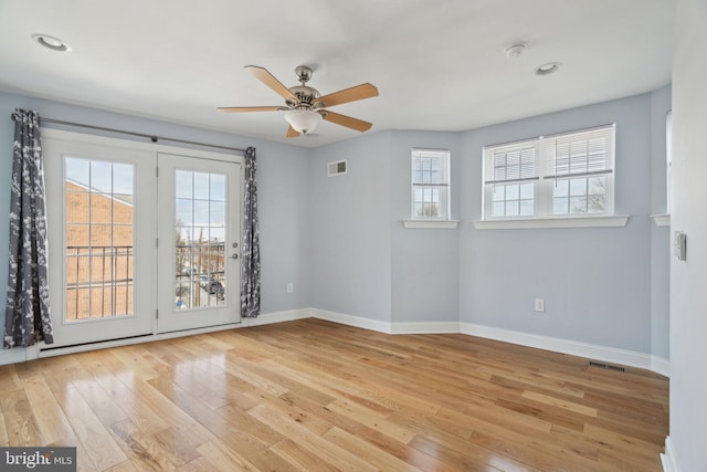 unfurnished room featuring ceiling fan, visible vents, baseboards, and hardwood / wood-style floors