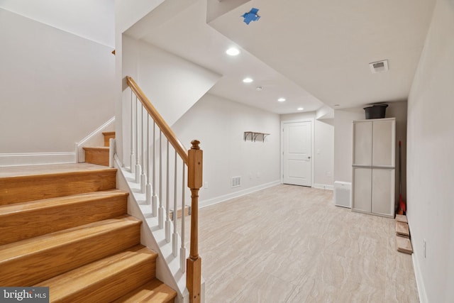 below grade area with recessed lighting, visible vents, baseboards, and stairway