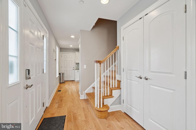 entryway with recessed lighting, baseboards, light wood-style flooring, and stairs