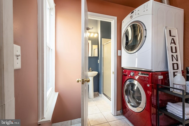 laundry area with light tile patterned floors and stacked washer / dryer